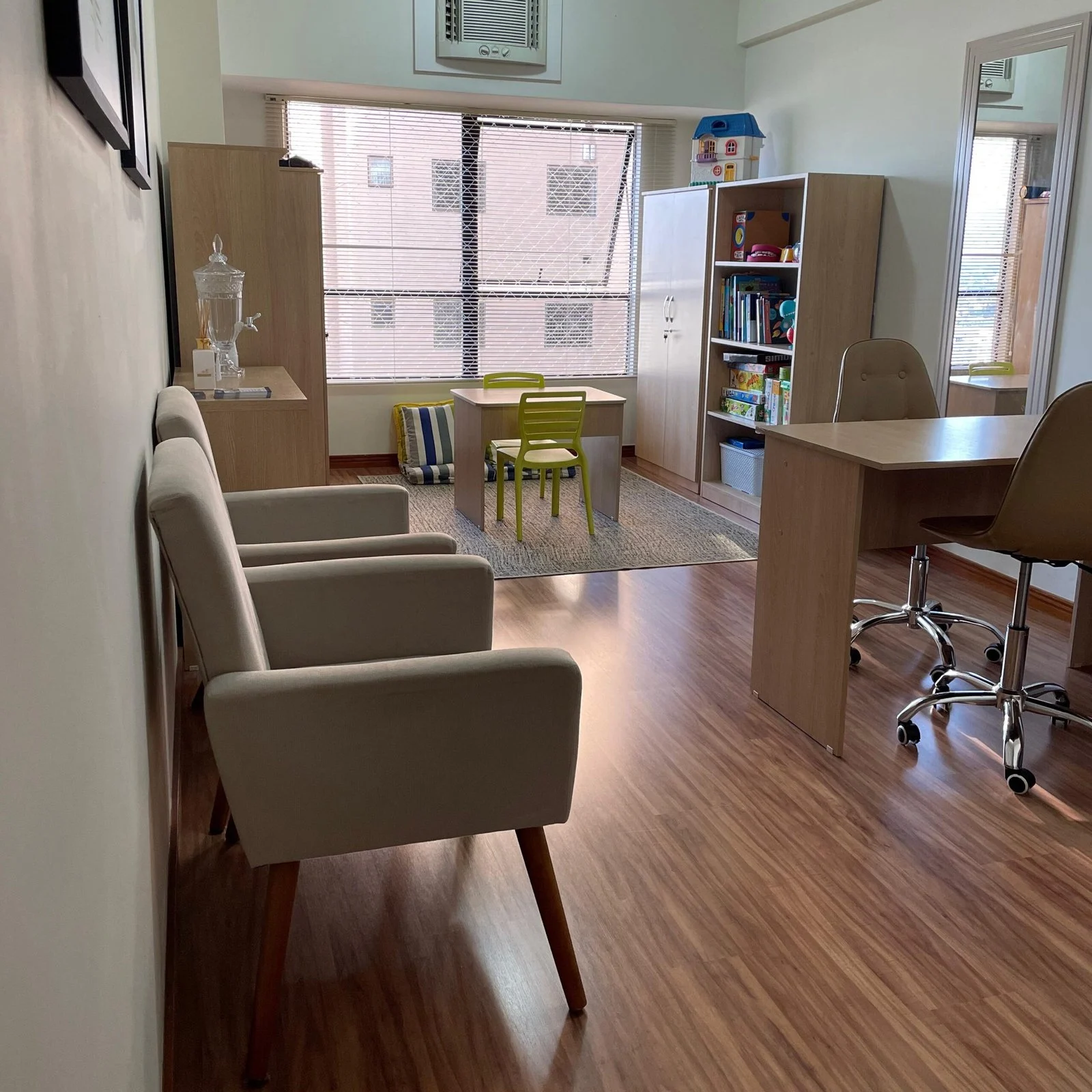 Vista do consultório com poltronas e mesa ao fundo
